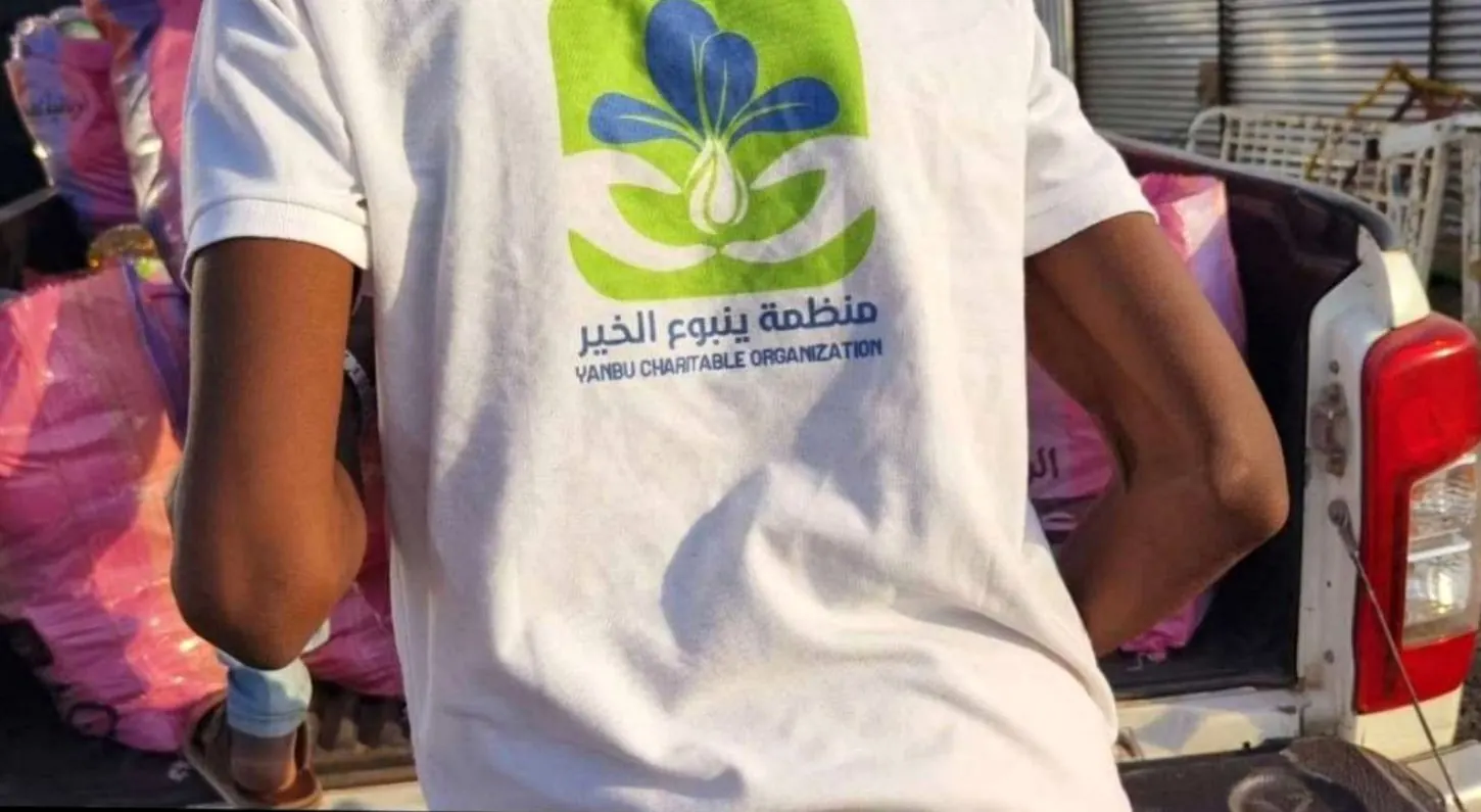 متطوع يرتدي قميص المنظمة أثناء تحميل المساعدات